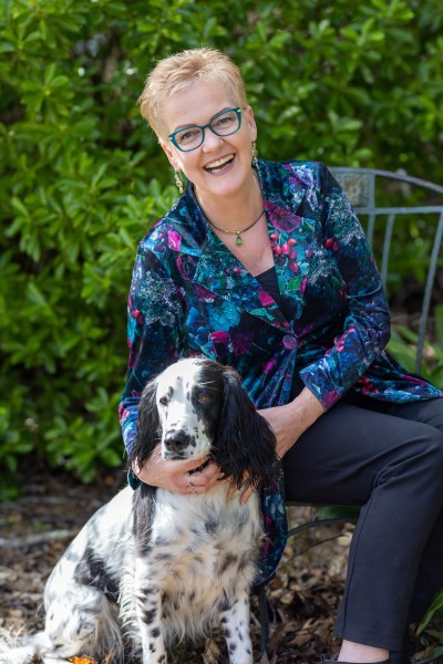 Rachel Clarke outside with her black and white spotted dog, smiling